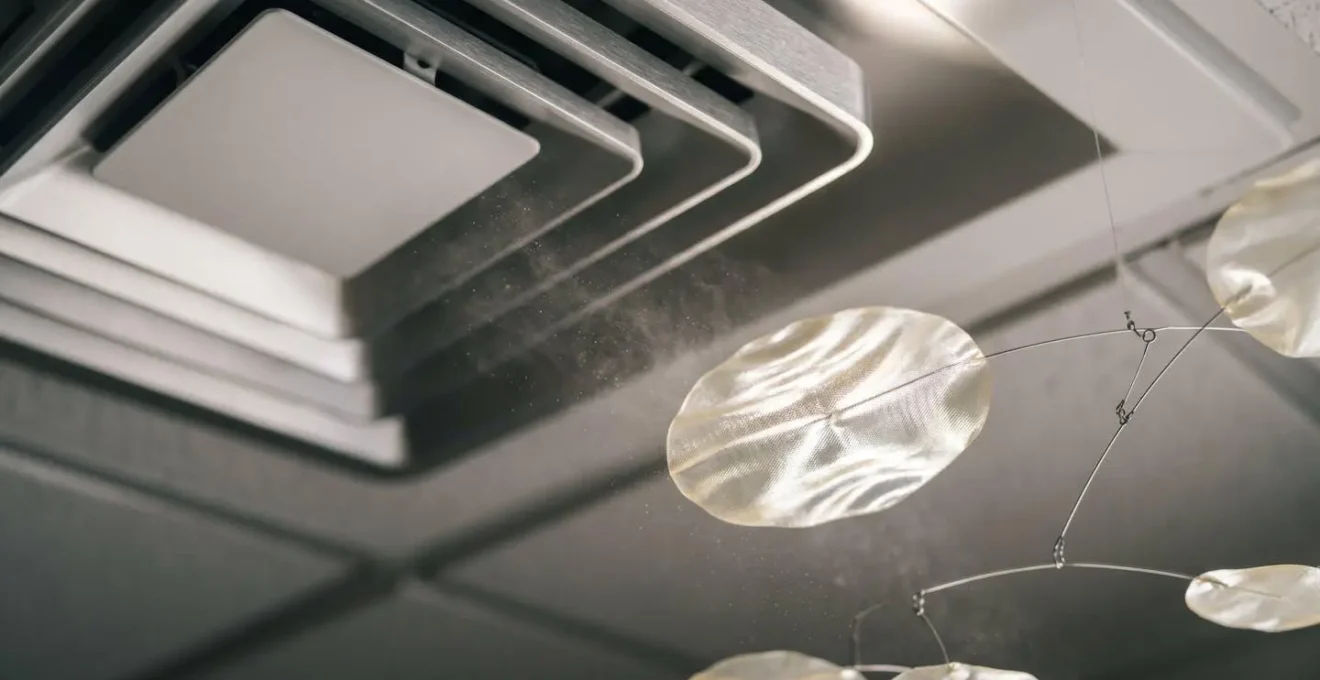 Close-up visualization of air current patterns around HVAC vent with suspended kinetic mobile element