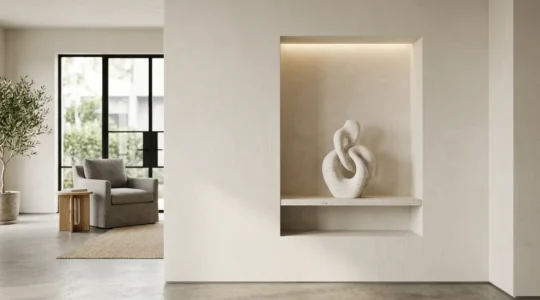 Professional photograph of a modern architectural niche with sculptural display illuminated by precise museum-grade lighting