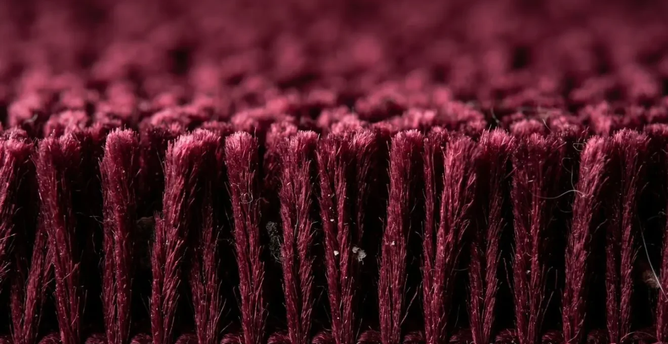 Extreme macro view of velvet pile fibers showing depth and shadow play that camouflages debris