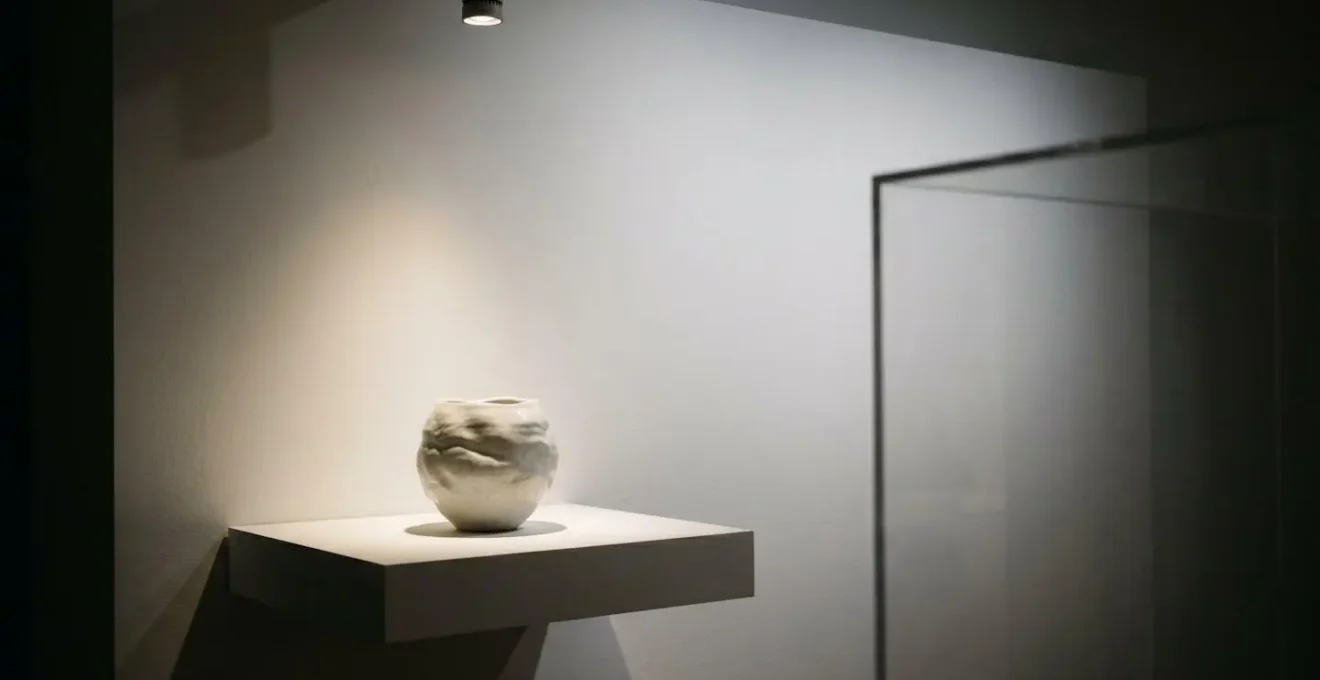 Professional museum-grade display setup showing UV-filtered lighting illuminating collectible homeware with protective measures